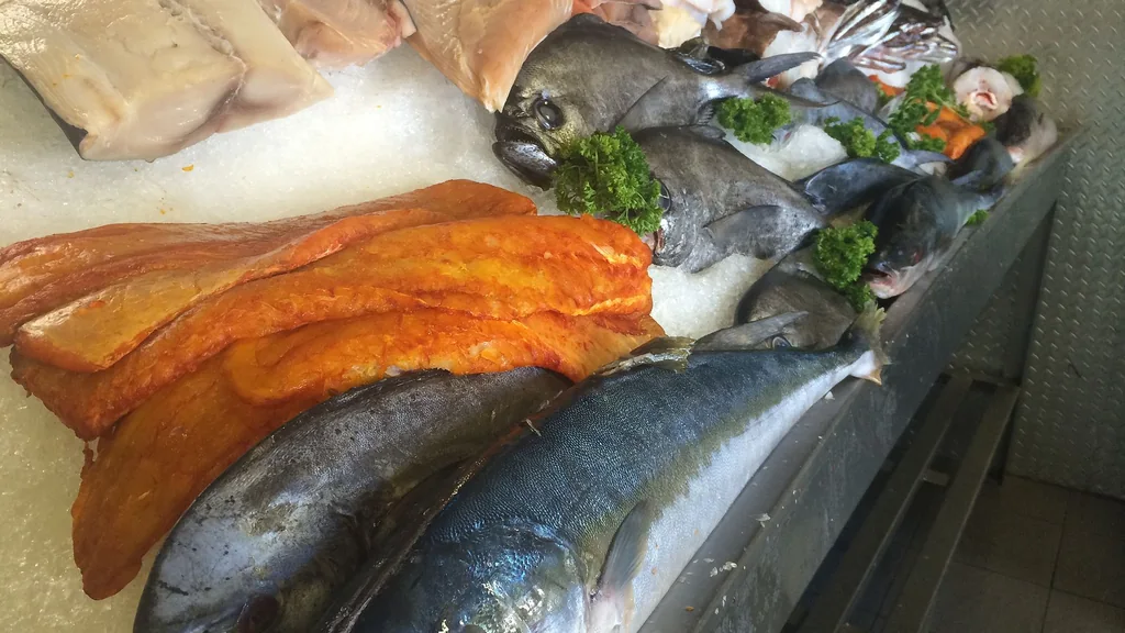 Pesce intero fresco esposto su ghiaccio